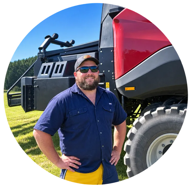 Logan Wall in front of the big square baler